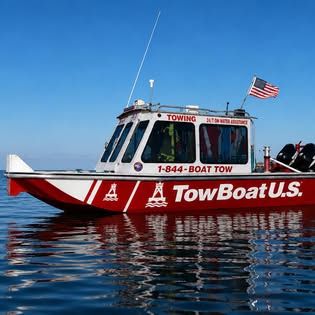 The red and white TowBoatUS Lake Fork vessel on the water with its branding and phone number visible.